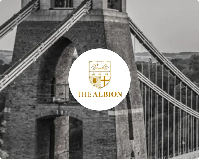 The Albion Bristol crest logo overlaid on a black and white close-up photograph of the Clifton Suspension Bridge tower in Bristol